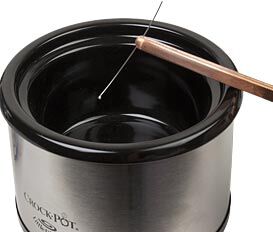 Tweezers placing wire into a crock pot